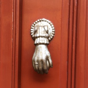 Batedor em forma de mão numa porta algures no Porto